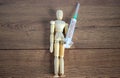 COVID-19 Pandemic Coronavirus concept. Wooden model of a man holding a syringe labeled antivirus