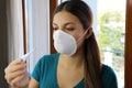 COVID-19 Pandemic Coronavirus Mask Fever Worry Woman Checking Temperature with Thermometer at Home Symptom of SARS-CoV-2. Girl