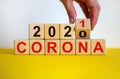 Covid-19 pandemic in 2021 symbol. Male hand flips a wooden cube and changes words `corona 2020` to `corona 2021`. Beautiful ye Royalty Free Stock Photo