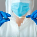 Covid 19 pcr test in nurse hands. Doctor in protective suit medical mask gloves holding Swab saliva sample for diagnostic covid19 Royalty Free Stock Photo