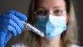 COVID-19 PCR test tube in doctor hand, woman in medical mask holds coronavirus swab collection kit Royalty Free Stock Photo