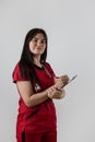 caucasian female doctor wear red uniform with stethoscope writing down patient info using clipboard Royalty Free Stock Photo