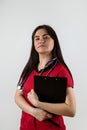 caucasian female doctor wear red uniform with stethoscope writing down patient info using clipboard Royalty Free Stock Photo