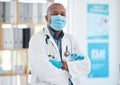 Covid, portrait and a doctor black man in a hospital office, standing arms crossed for healthcare or insurance. Medical Royalty Free Stock Photo