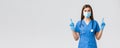 Covid-19, preventing virus, health, healthcare workers and quarantine concept. Curious female doctor or nurse in blue Royalty Free Stock Photo