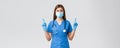 Covid-19, preventing virus, health, healthcare workers and quarantine concept. Curious female doctor or nurse in blue Royalty Free Stock Photo