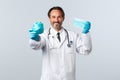 Covid-19, preventing virus, healthcare workers and vaccination concept. Smiling charismatic doctor in gloves and white