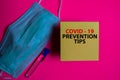 Covid - 19 Prevention Tips write on a sticky note isolated on Office Desk. Healthcare/Medical concept