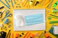 Covid-19 protection with mask on notebook and tools around yellow Royalty Free Stock Photo