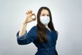 Covid19, quarantine. Happy girl show ok in medical face mask. stay safe during coronavirus outbreak