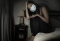 Covid-19 quarantine and home lockdown - young beautiful scared and overwhelmed Asian Chinese woman in protective mask feeling