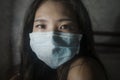Covid-19 quarantine and home lockdown - dramatic portrait of young beautiful scared and overwhelmed Asian Korean woman in