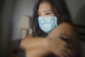 Covid-19 quarantine and home lockdown - dramatic portrait of young beautiful scared and overwhelmed Asian Korean woman in