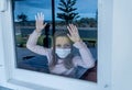 COVID-19 Quarantine. Sad little girl looking through the window feeling lonely during lockdown Royalty Free Stock Photo