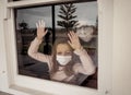 COVID-19 Quarantine. Sad little girl looking through the window feeling lonely during lockdown Royalty Free Stock Photo