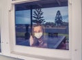 COVID-19 Quarantine. Sad little girl looking through the window feeling lonely during lockdown Royalty Free Stock Photo