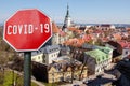 COVID-19 red sign on Tallinn old town background, Estonia. View from above of towers in Tallinn. Top view of Tallinn city center Royalty Free Stock Photo