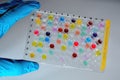 Covid-19 sample plate mutant screening colorful - scientist holding a high throughput 96 well microtiter plate