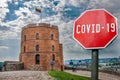 COVID-19 sign against view of Gedeminas tower in Vilnius city center, Lithuania. Warning about pandemic in Lithuania. Coronavirus