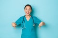 Covid-19, social distancing and coronavirus pandemic concept. Cheerful smiling asian female doctor, nurse in lab or Royalty Free Stock Photo