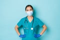 Covid-19, social distancing and coronavirus pandemic concept. Cheerful smiling asian female doctor, nurse in scrubs and Royalty Free Stock Photo