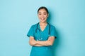 Covid-19, social distancing and coronavirus pandemic concept. Cheerful smiling asian female doctor, physician or nurse Royalty Free Stock Photo