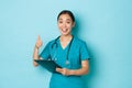Covid-19, social distancing and coronavirus pandemic concept. Cheerful smiling asian female nurse encourage patient Royalty Free Stock Photo