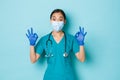 Covid-19, social distancing and coronavirus pandemic concept. Excited and amazed asian female doctor, nurse in scrubs Royalty Free Stock Photo