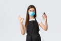 Covid-19 social distancing, employees, coffee shops, coronavirus concept. Barista or waitress in medical mask showing