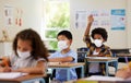 Covid, students and education children in school classroom raising hand to answer, ask or question lesson with Royalty Free Stock Photo