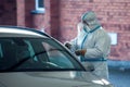 Covid-19 testing. A doctor in a protective suit taking mouth swab from a person to test for possible coronavirus infection