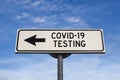 COVID-19 testing road sign, arrow on blue sky background. One way blank road sign with copy space. Arrow on a pole pointing in one Royalty Free Stock Photo