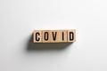 ` covid ` text made of wooden cube on White background with shadow