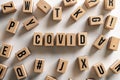 ` covid ` text made of wooden cube on White background with pile words