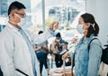 Covid traveling with a doctor taking temperature of a woman wearing a mask in an airport for safety in a pandemic