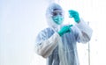 COVID-19 vaccinate concept. Asian doctor with medical glove, mask and PPE suit is holding syringe and Corona virus vaccine Royalty Free Stock Photo