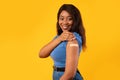 Cheerful Vaccinated African Woman Showing Arm After Vaccine Injection, Studio