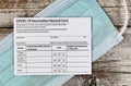 Covid 19 vaccination record card with facemask in close up view.  Individual record for use during the covid 19 coronavirus global Royalty Free Stock Photo