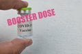 Covid-19 vaccine ampoule with text BOOSTER DOSE