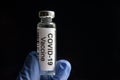 COVID-19 vaccine on black background, medication bottle for SARS-CoV-2 corona virus cure