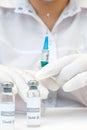 COVID-19 vaccine in researcher hands, female doctor holds syringe and bottle with vaccine for coronavirus cure. Concept of corona Royalty Free Stock Photo