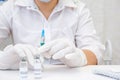 COVID-19 vaccine in researcher hands, female doctor holds syringe and bottle with vaccine for coronavirus cure. Concept of corona Royalty Free Stock Photo