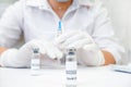 COVID-19 vaccine in researcher hands, female doctor holds syringe and bottle with vaccine for coronavirus cure. Concept of corona Royalty Free Stock Photo