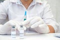 COVID-19 vaccine in researcher hands, female doctor holds syringe and bottle with vaccine for coronavirus cure. Concept of corona Royalty Free Stock Photo