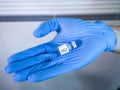 Covid-19 vaccine vial held by the gloved hand of a healthcare staff Royalty Free Stock Photo