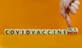 Covid vaccine yes or no symbol. Hand turns cubes and changes words `covid vaccine no` to `covid vaccine yes`. Beautiful orange