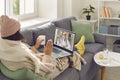 Sick woman sitting on couch and video calling eHealth doctor for online medical consultation