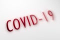 Covid - 19 word in red shadow on a white shaded background.