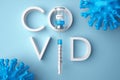 COVID word, a syringe, a vaccine bottle and virus cells.