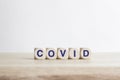 Covid - word from wooden blocks with letters on a table